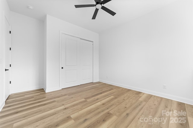 unfurnished bedroom featuring light hardwood / wood-style flooring, a closet, and ceiling fan