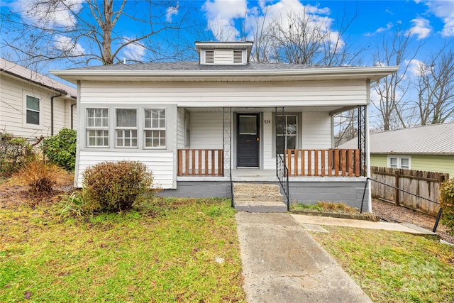 bungalow-style home with covered porch and a front yard