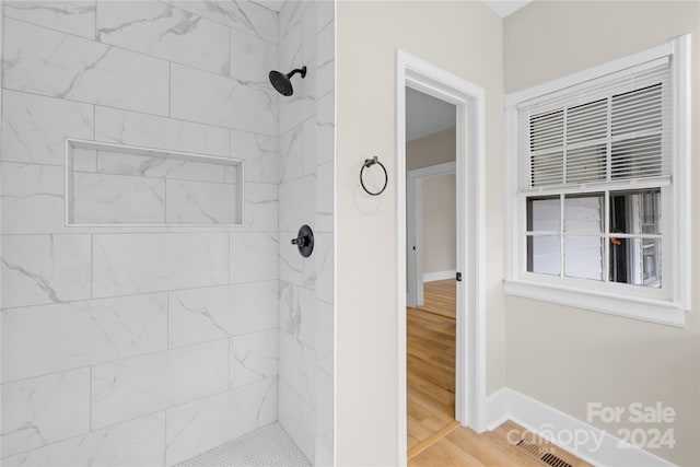 bathroom featuring a tile shower and hardwood / wood-style flooring