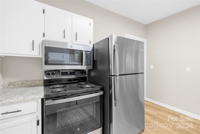 kitchen featuring white cabinetry, light hardwood / wood-style floors, light stone counters, and appliances with stainless steel finishes