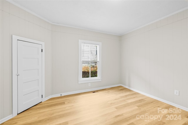 unfurnished room featuring hardwood / wood-style floors and crown molding