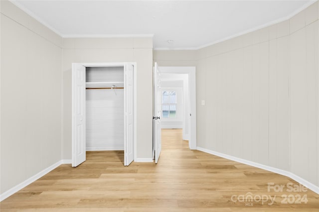 unfurnished bedroom featuring a closet, light hardwood / wood-style flooring, and ornamental molding