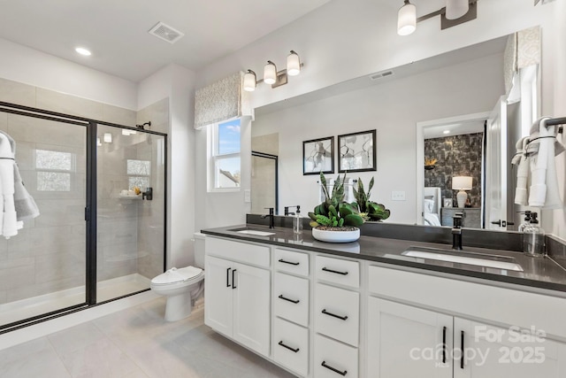 bathroom with tile patterned floors, toilet, vanity, and walk in shower