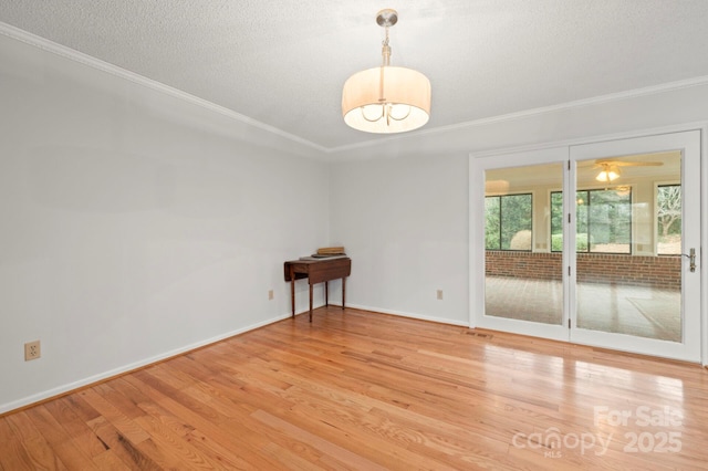 unfurnished room featuring light wood-style floors, crown molding, a textured ceiling, and baseboards