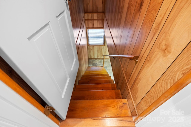 stairs featuring wood walls