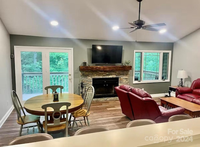 living room featuring ceiling fan, a fireplace, and hardwood / wood-style flooring