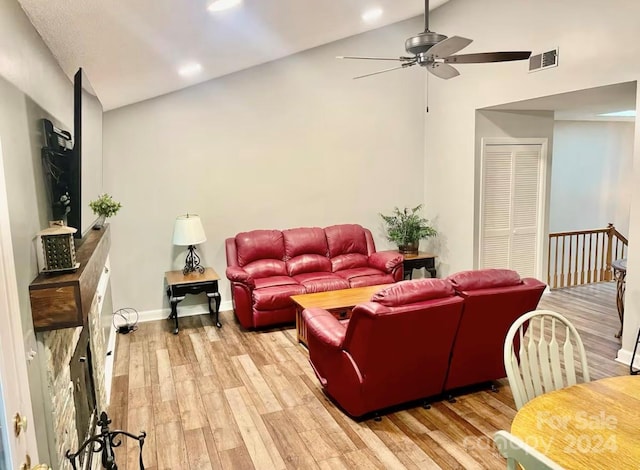 living room featuring ceiling fan, light hardwood / wood-style flooring, and vaulted ceiling