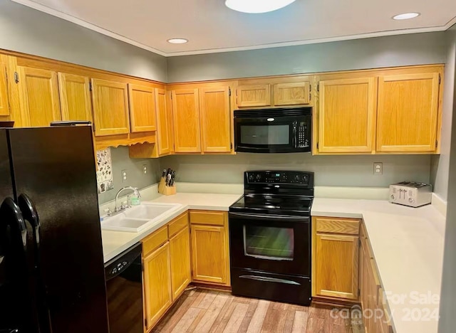 kitchen with sink, light hardwood / wood-style flooring, and black appliances