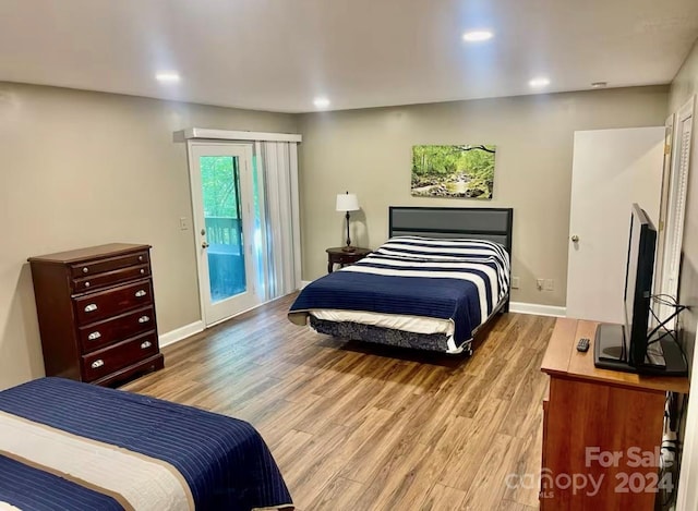 bedroom with access to exterior and light hardwood / wood-style floors