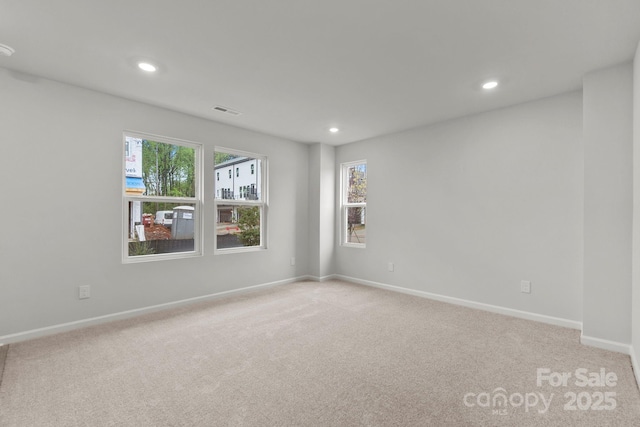 empty room featuring light carpet and a wealth of natural light