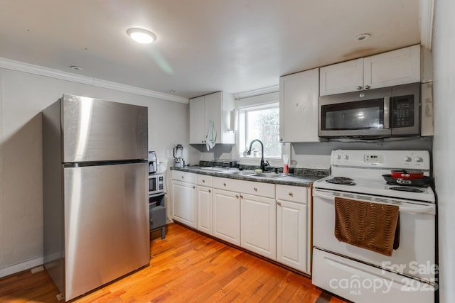 kitchen featuring stainless steel appliances, white cabinetry, light hardwood / wood-style floors, and sink