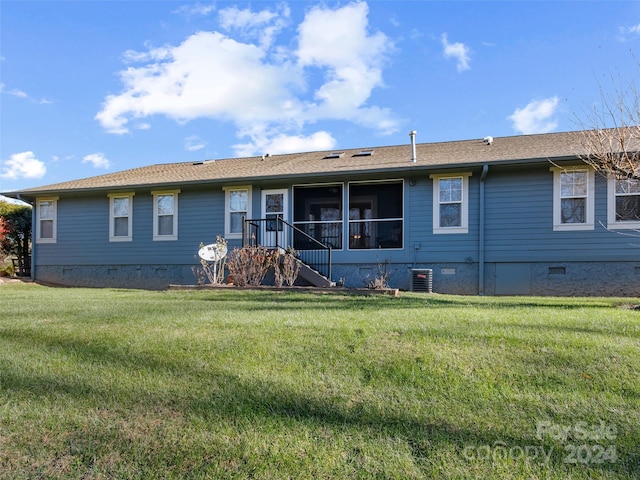 rear view of house featuring a lawn and a sunroom