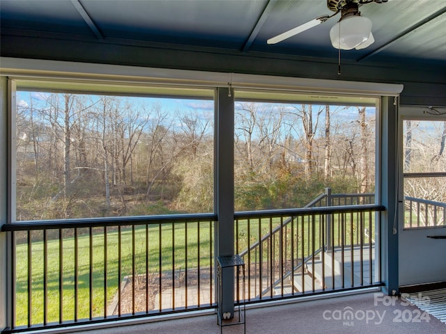 unfurnished sunroom featuring ceiling fan