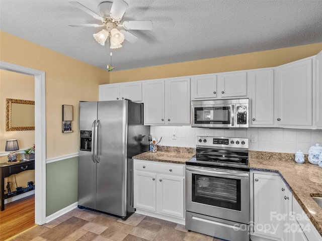 kitchen featuring appliances with stainless steel finishes, tasteful backsplash, a textured ceiling, ceiling fan, and white cabinetry