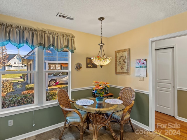 dining space featuring hardwood / wood-style floors and a textured ceiling