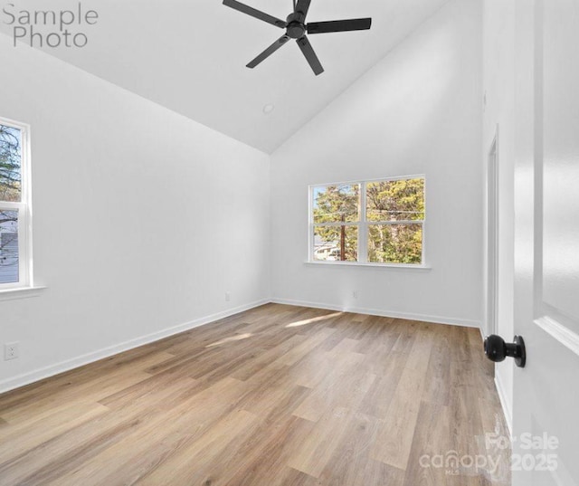 empty room featuring ceiling fan, light wood-type flooring, and high vaulted ceiling