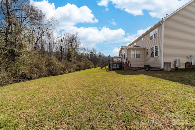 view of yard with central AC and a deck