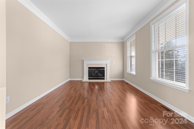 unfurnished living room featuring crown molding and dark hardwood / wood-style flooring