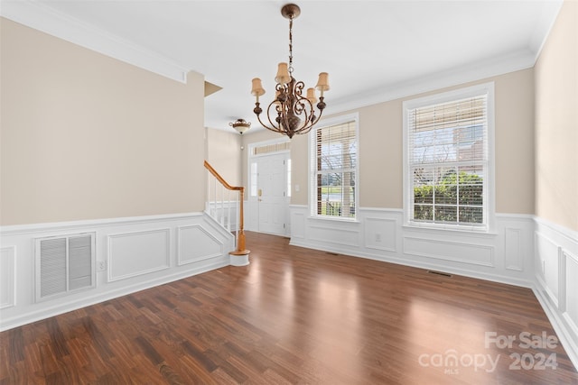 interior space with dark hardwood / wood-style flooring, crown molding, and a chandelier