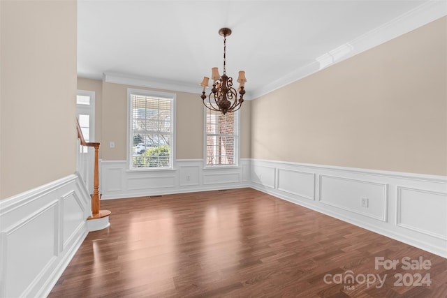 unfurnished dining area with hardwood / wood-style floors and an inviting chandelier