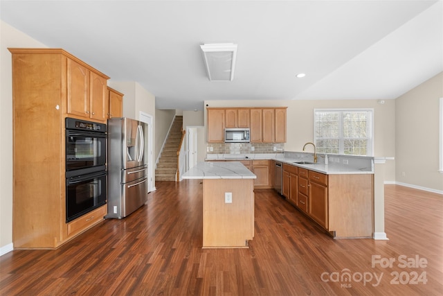 kitchen with a center island, sink, stainless steel appliances, tasteful backsplash, and dark hardwood / wood-style floors