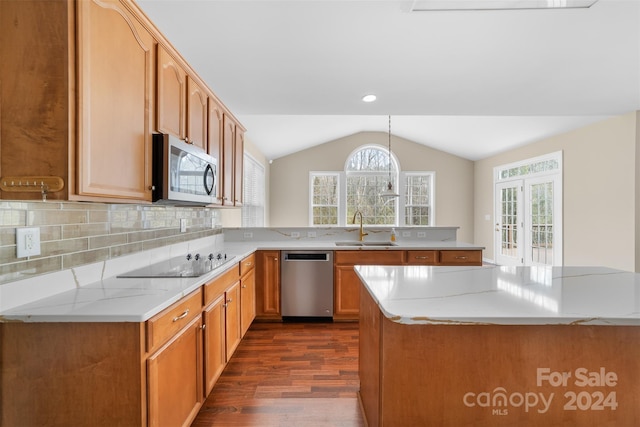 kitchen featuring sink, hanging light fixtures, kitchen peninsula, decorative backsplash, and appliances with stainless steel finishes