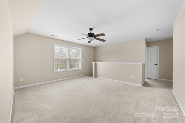 carpeted empty room with ceiling fan and lofted ceiling