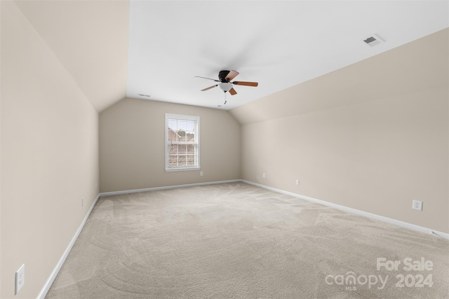 additional living space with ceiling fan, light colored carpet, and lofted ceiling