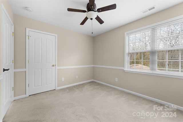 unfurnished room featuring ceiling fan and light colored carpet