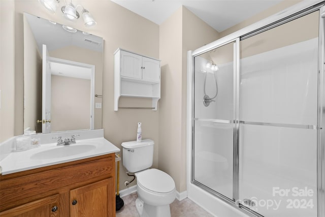 bathroom featuring tile patterned floors, vanity, toilet, and walk in shower