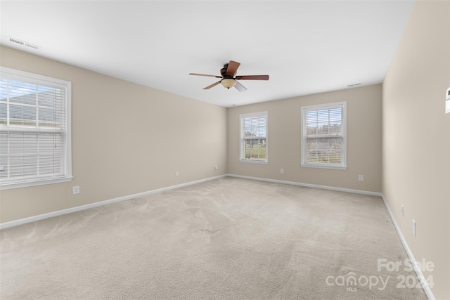 spare room featuring ceiling fan and light colored carpet