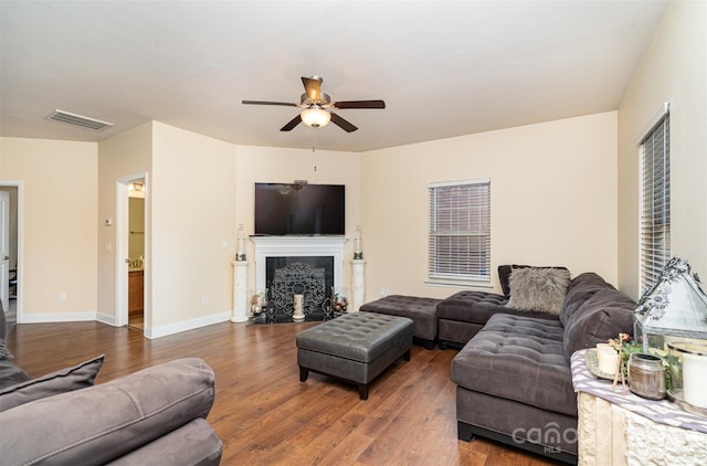 living room with ceiling fan and dark wood-type flooring