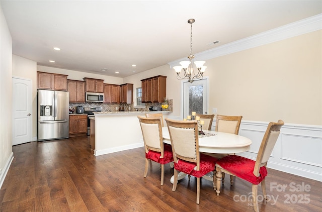 dining space featuring ornamental molding, dark wood-type flooring, and a notable chandelier