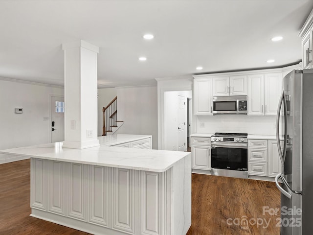 kitchen featuring white cabinetry, light stone countertops, dark hardwood / wood-style floors, kitchen peninsula, and appliances with stainless steel finishes