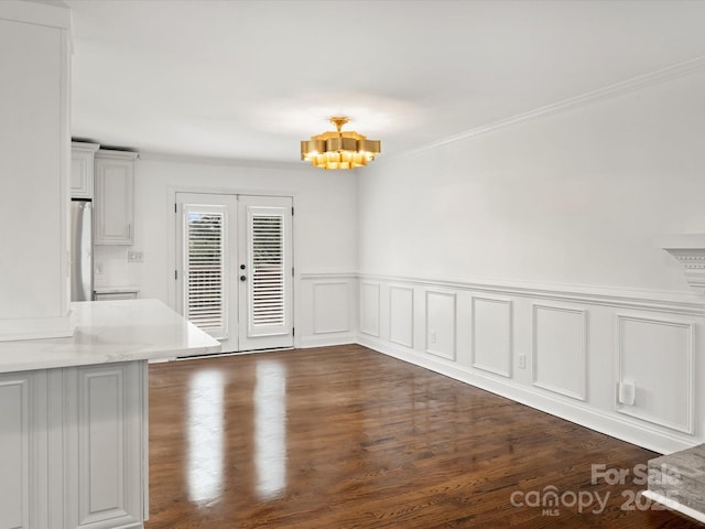 unfurnished dining area with french doors, dark hardwood / wood-style floors, and a notable chandelier