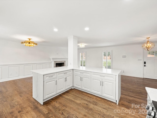 kitchen with white cabinets, decorative light fixtures, an inviting chandelier, and dark hardwood / wood-style floors