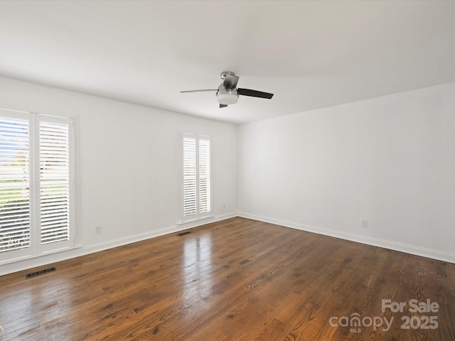 empty room featuring ceiling fan and dark wood-type flooring