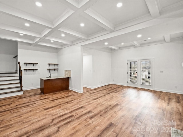 unfurnished living room with french doors, ornamental molding, coffered ceiling, beam ceiling, and light hardwood / wood-style flooring