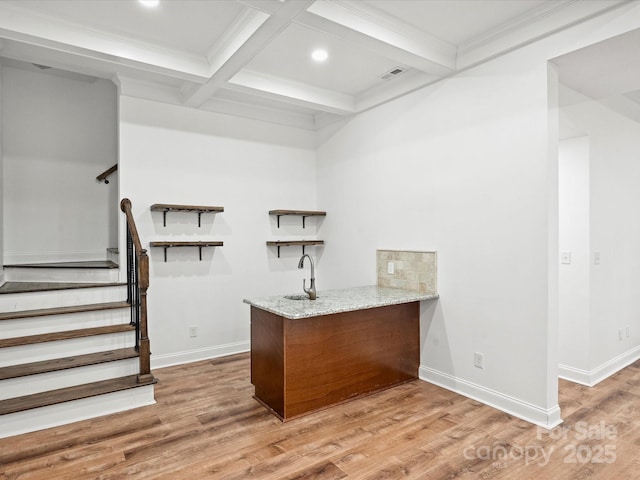 bar with beam ceiling, coffered ceiling, light stone counters, crown molding, and light hardwood / wood-style floors