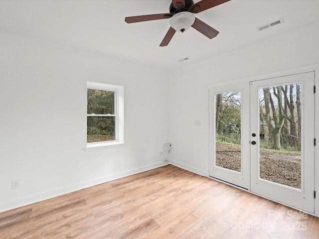 spare room with ceiling fan, a healthy amount of sunlight, and light hardwood / wood-style floors