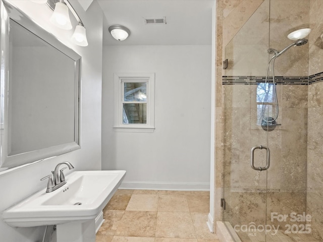 bathroom featuring an enclosed shower and sink