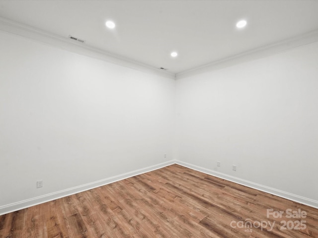 empty room with crown molding and wood-type flooring