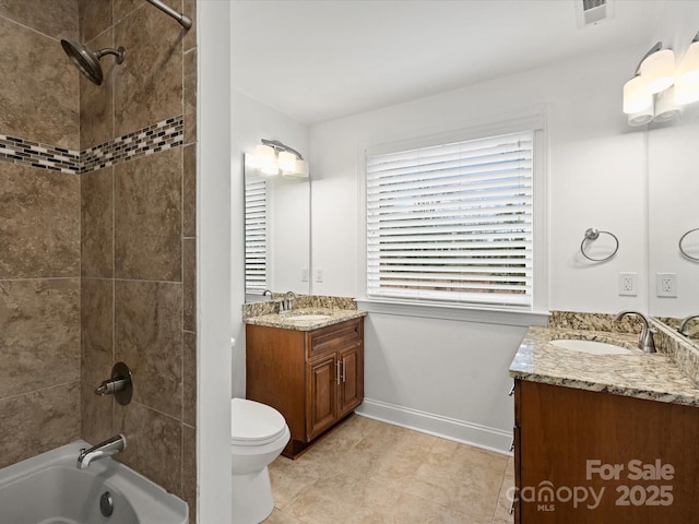 full bathroom featuring tile patterned floors, vanity, toilet, and tiled shower / bath