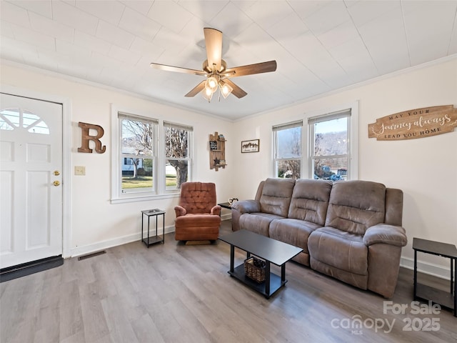 living room featuring crown molding, ceiling fan, and light wood-type flooring