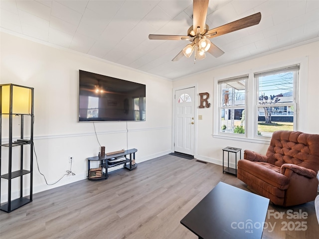 living room featuring crown molding, hardwood / wood-style floors, and ceiling fan