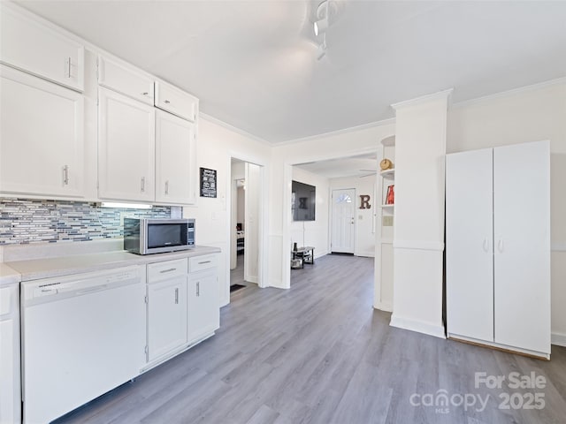 kitchen with decorative backsplash, white cabinets, ornamental molding, dishwasher, and light hardwood / wood-style floors