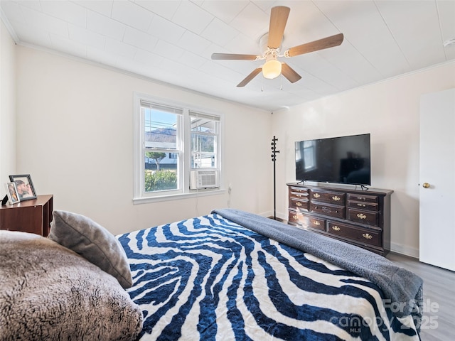 bedroom with ceiling fan, crown molding, cooling unit, and hardwood / wood-style flooring