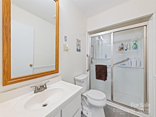 bathroom featuring vanity, toilet, and a shower with door