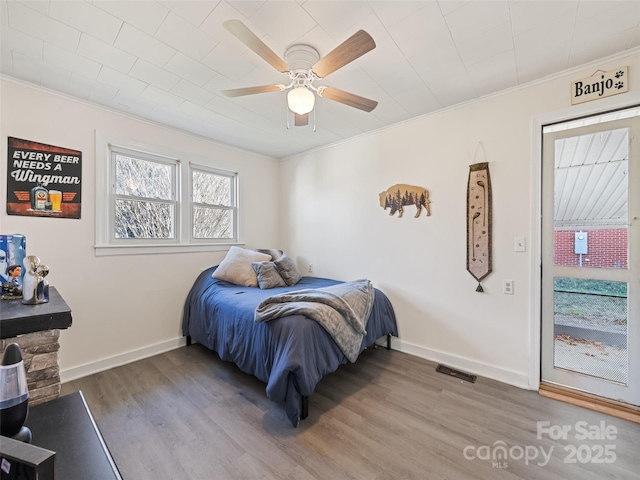 bedroom featuring hardwood / wood-style flooring, ceiling fan, and ornamental molding