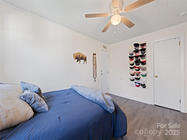 bedroom with hardwood / wood-style flooring, ceiling fan, and crown molding